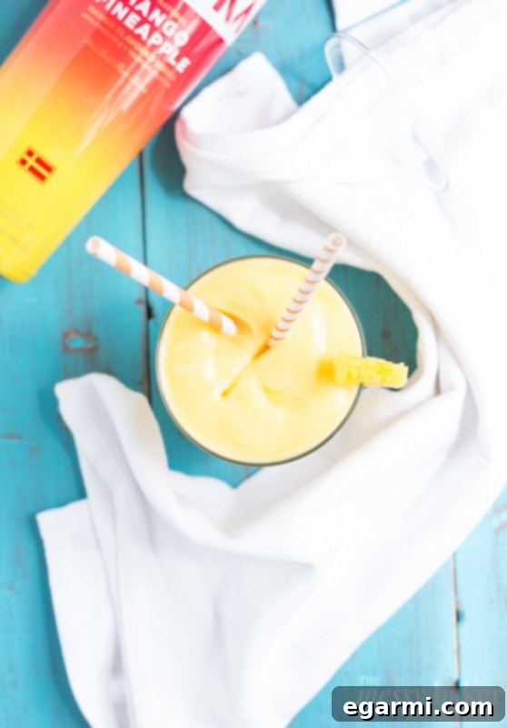 A Close-up of a Beautifully Layered Pineapple Mango Slush Cocktail in a Glass