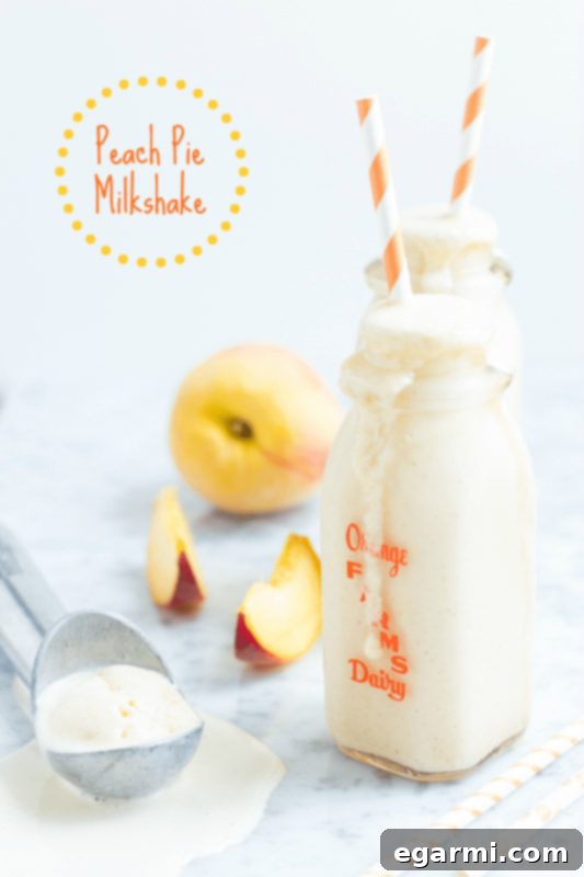 Delicious Peach Pie Milkshake topped with whipped cream and cinnamon, served in a tall glass. A perfect summer treat.