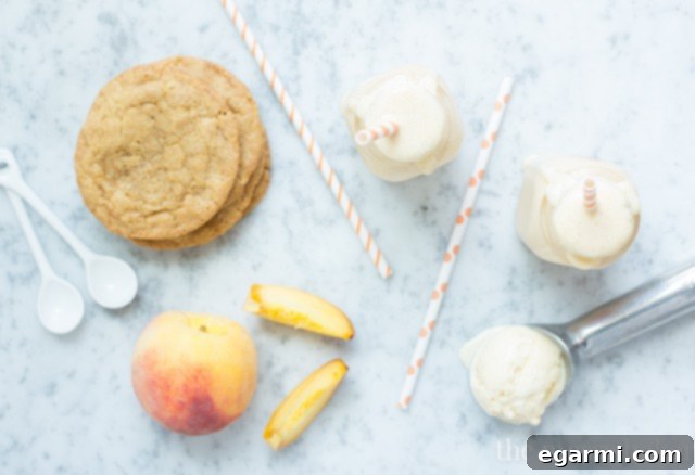 Overhead shot of two tall glasses of Peach Pie Milkshake, garnished with whipped cream and cinnamon, inviting a refreshing sip.