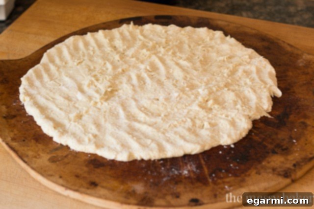 Shaping gluten-free pizza dough by hand on a baking sheet