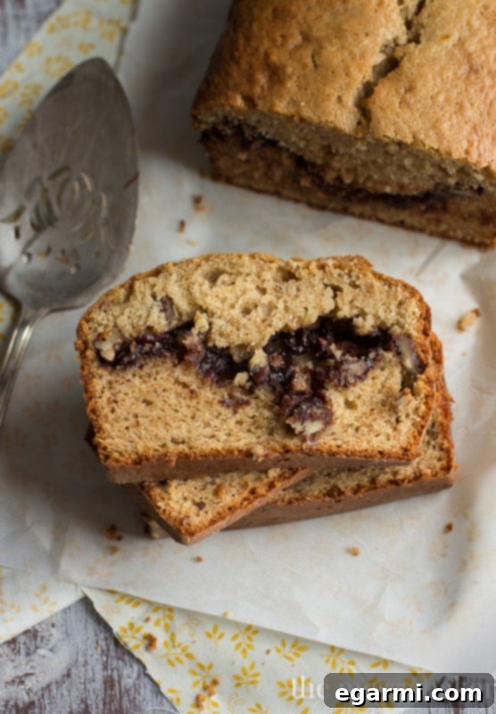 A delicious slice of Nutella & Toasted Pecan Swirl Banana Bread with a visible gooey center.