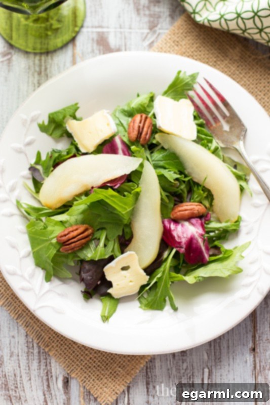 Close-up of a poached pear half, showing its tender texture and elegant presentation, ready for the salad.