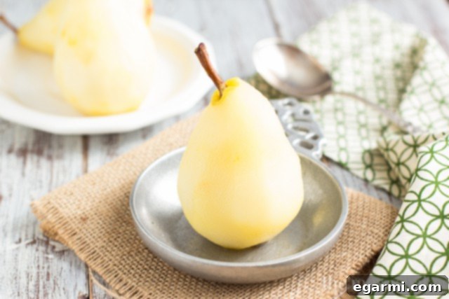 Pears simmering gently in a white wine poaching liquid, infusing with flavor.