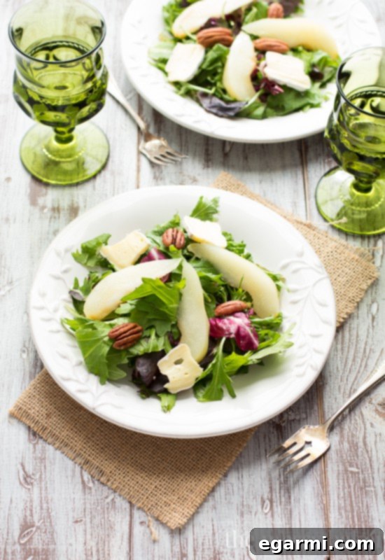 Finished Poached Pear and Brie Salad, beautifully dressed with balsamic vinaigrette and ready to serve.