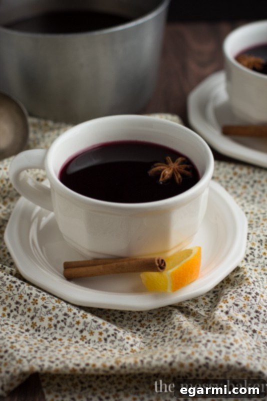 Cozy Pomegranate Mulled Wine for Sunday Supper 7 Pomegranate Mulled Wine | Served in a clear glass with orange and cinnamon garnish