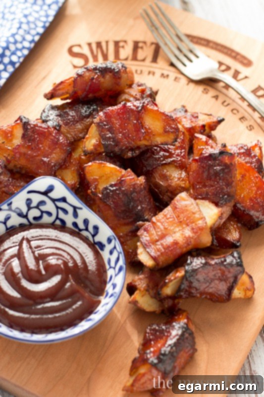 Crispy bacon-wrapped potato wedges freshly baked and glazed with Sweet Baby Ray's Barbecue Sauce, a perfect appetizer for any gathering.