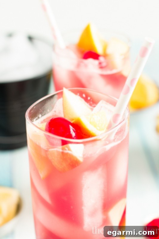 Glasses of Black Cherry Sangria with fresh fruit and a pitcher