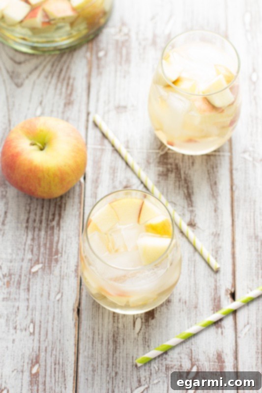 Sparkling Caramel Apple Sangria in a pitcher with fresh apple slices