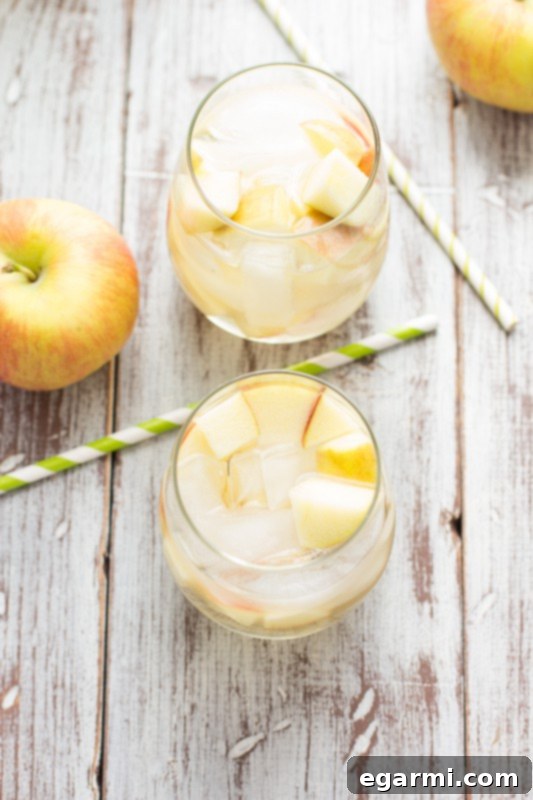 Sparkling Caramel Apple Sangria in a pitcher with fresh apples