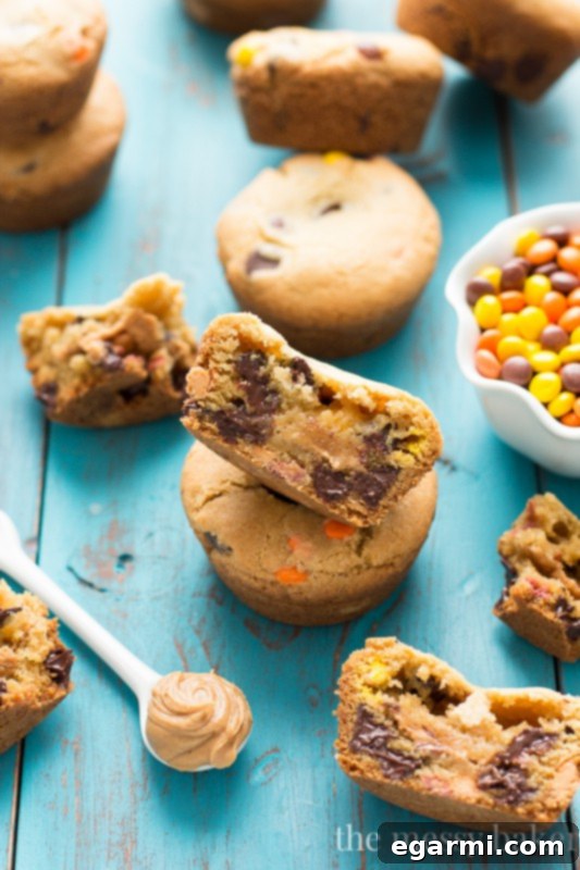 Two Peanut Butter Stuffed Chocolate Chip Cookie Cups on a plate, one broken to show the gooey center