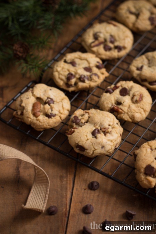 A stack of golden brown butter pecan chocolate chip cookies, showcasing their thick texture and visible chocolate chips and pecans.