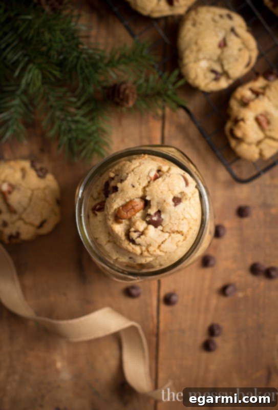 A single, perfectly golden brown butter pecan chocolate chip cookie on a plate, showcasing its texture and delicious inclusions.