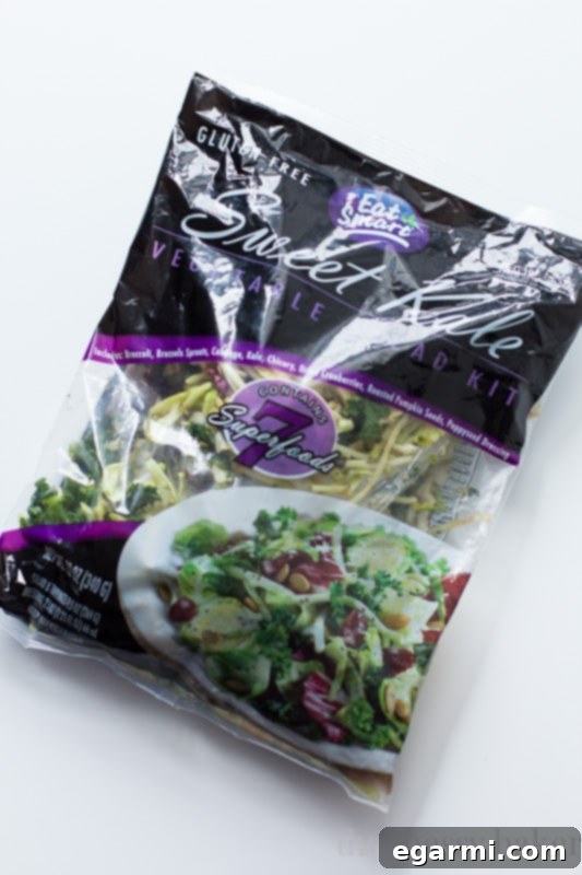 Close-up of the Eat Smart Sweet Kale Salad Kit contents before preparation, showing fresh kale, Brussels sprouts, and other greens.