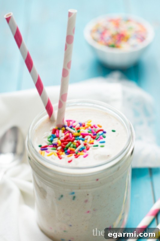 A refreshing glass of Healthy Funfetti Shake, topped with a generous amount of colorful sprinkles, ready to be enjoyed.