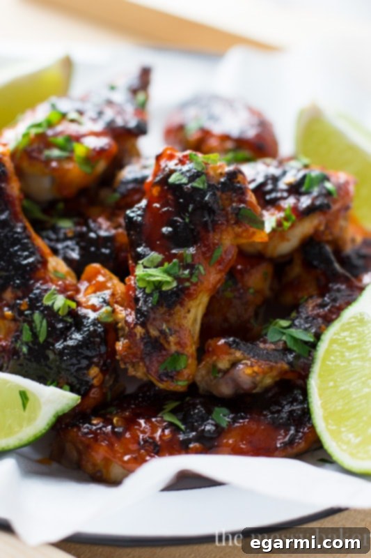 Close-up of golden-brown baked sriracha wings, showcasing crispy skin and sticky glaze