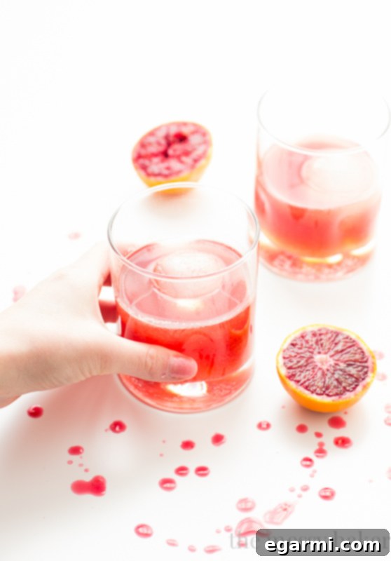 Another perspective of the Blood Orange Bourbon Fizz, showcasing its vibrant color