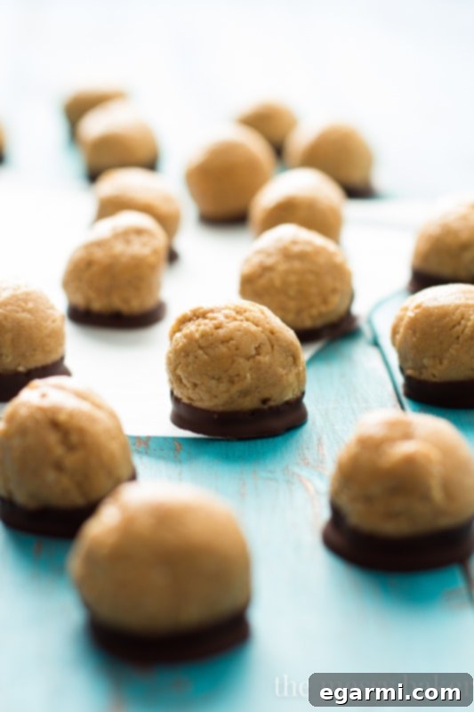 Three healthy peanut butter buckeyes arranged artfully on a white surface, showcasing the chocolate and peanut butter
