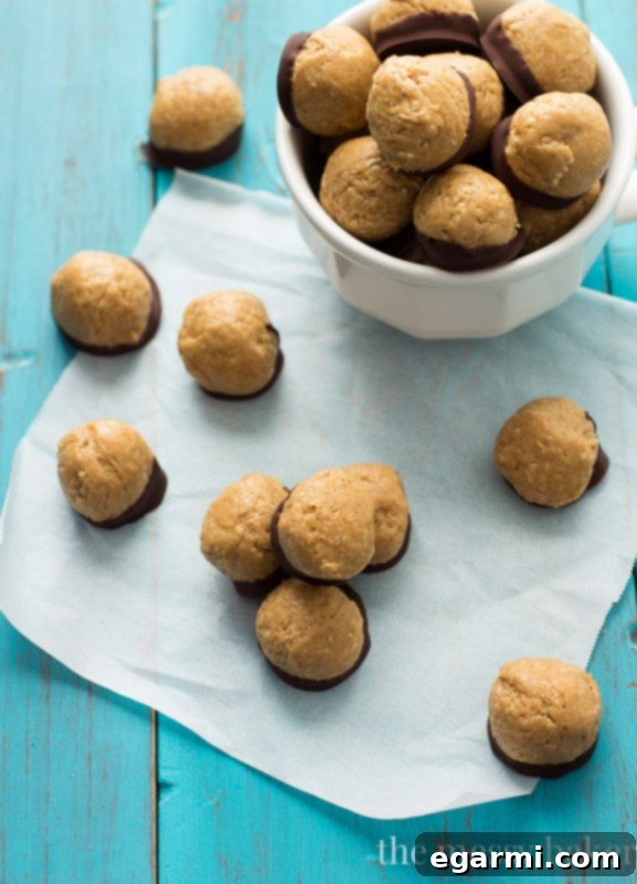 Close-up of freshly made healthy peanut butter buckeyes on a parchment-lined tray, showing texture