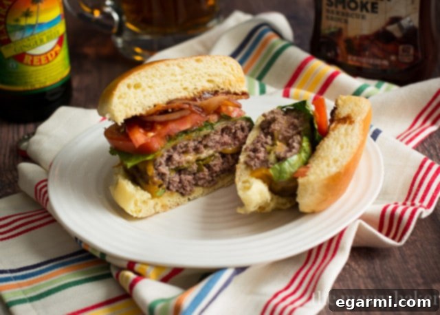 A plate with three halves of Jalapeño Popper Stuffed Bacon Burgers, showing the melted cheese.