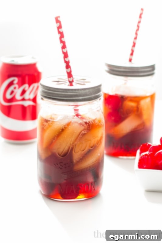Refreshing Black Cherry Cuba Libre Cocktail served in a glass with ice and cherries, a sophisticated adult cherry coke alternative.