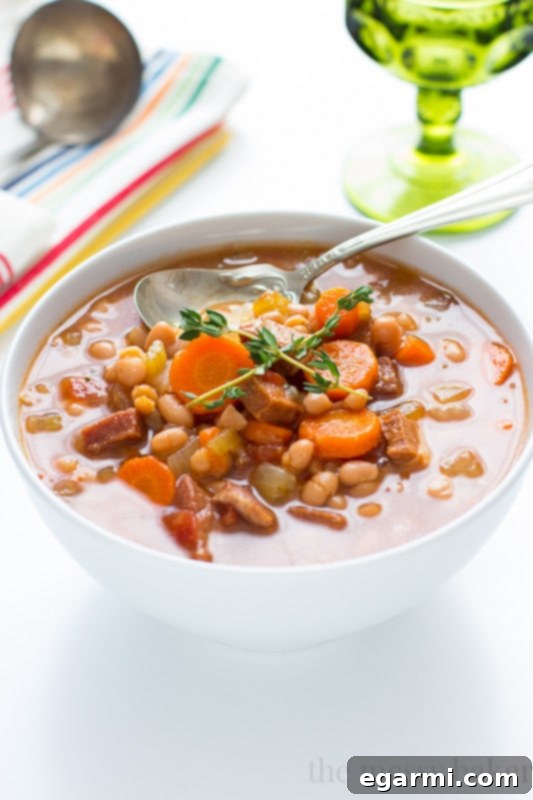 Ingredients for Slow Cooker Navy Bean Soup with Ham, including fresh herbs and vegetables