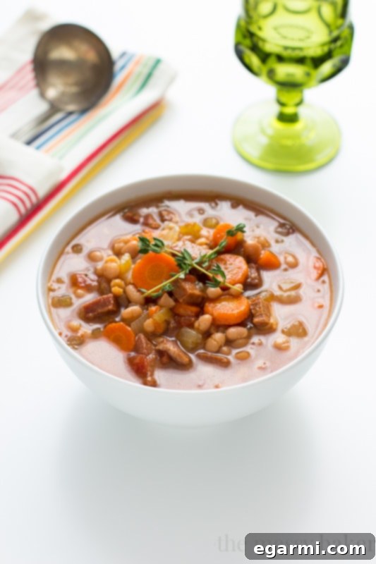 Serving Slow Cooker Navy Bean Soup with Ham with crusty bread and fresh herbs
