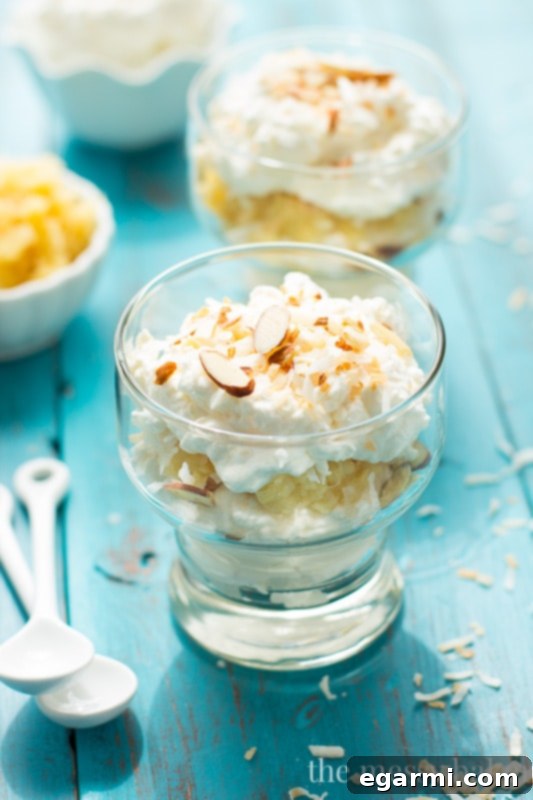 Several individual servings of Pina Colada Fool in clear glasses, garnished with toasted coconut and almonds.