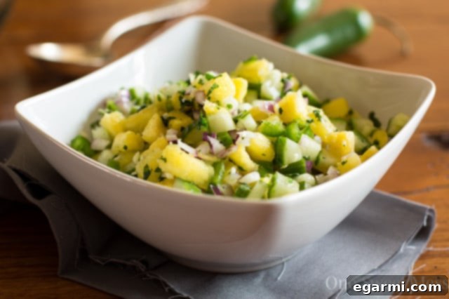 Pineapple Cucumber Salsa served in a white bowl with a spoon