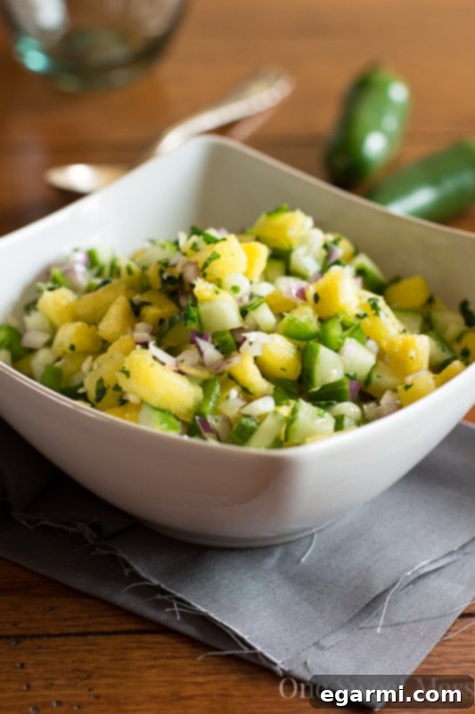 Two bowls, one with Pineapple Cucumber Salsa and another with Guacamole, ready for dipping