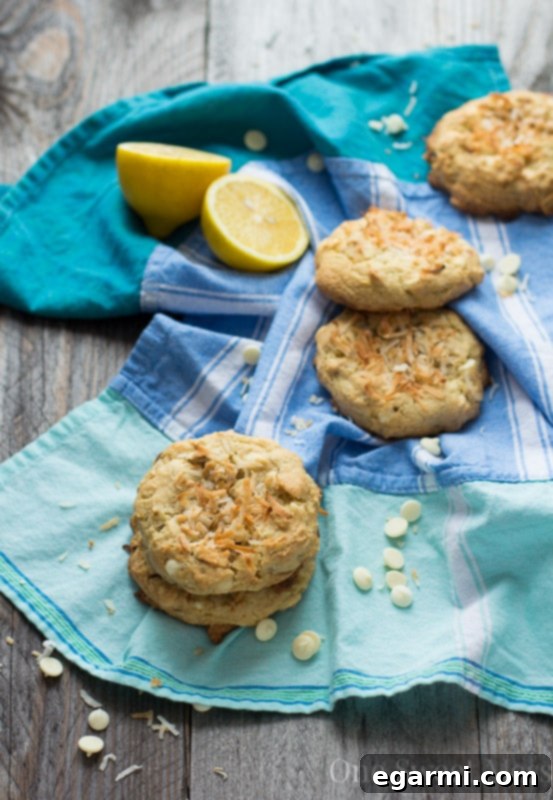 Freshly baked Soft-Baked Lemon Coconut Cookies cooling on a wire rack, showcasing their uniform size and golden edges.