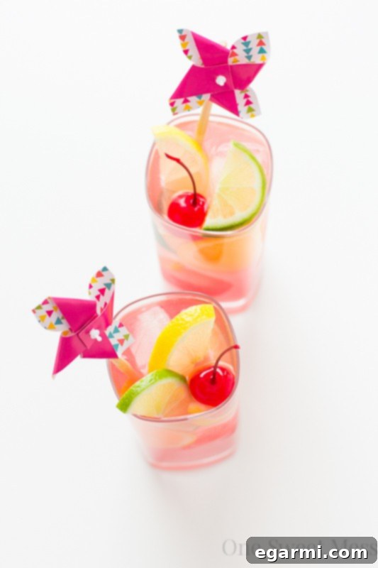 Glass of vibrant Tiki Punch brimming with fresh fruit slices and ice, ready to be enjoyed on a hot day