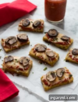 Mini Polenta Pizza Bites stacked with fresh basil
