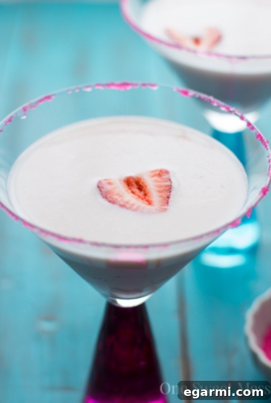 Strawberry Shortcake Martini for Thirsty Thursdays 3 Strawberry Shortcake Martini with a pink sugar rim and fresh strawberry slice, ready to be enjoyed