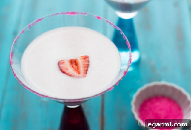 Strawberry Shortcake Martini for Thirsty Thursdays 4 Refreshing Strawberry Shortcake Martini on a white surface, garnished with fresh strawberries