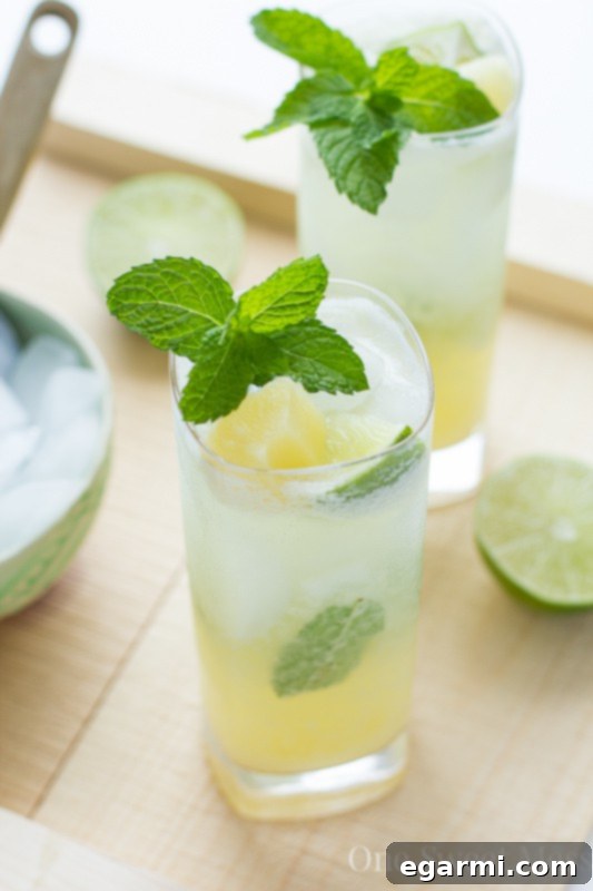 Refreshing Pineapple Coconut Mojito in a clear glass on a rustic surface