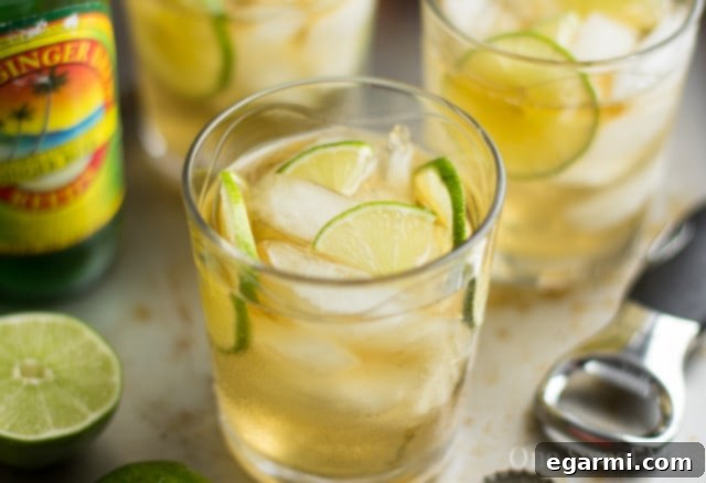 Three essential ingredients for a Dark & Stormy: Spiced Rum bottle, Ginger Beer bottle, and fresh limes