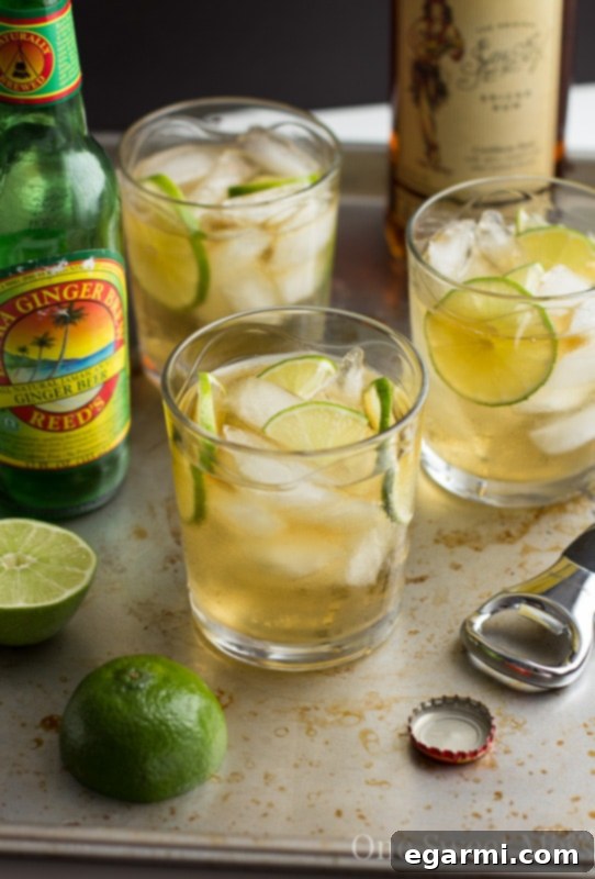 Pouring a stream of ginger beer into a glass with ice and rum for a Dark & Stormy