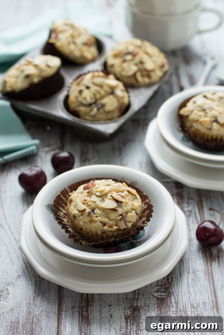 Decadent Cherry Chocolate Chip Muffins 5 A bowl of fresh cherries, some already pitted, next to a cherry pitter tool.