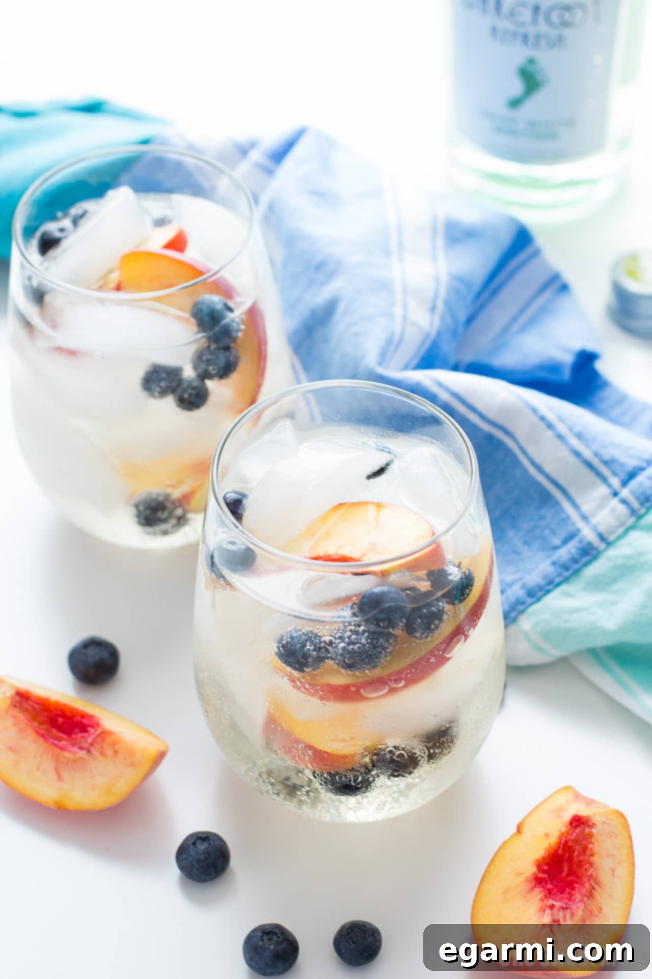 Pitcher of Blueberry Peach Sangria garnished with fresh peaches and blueberries