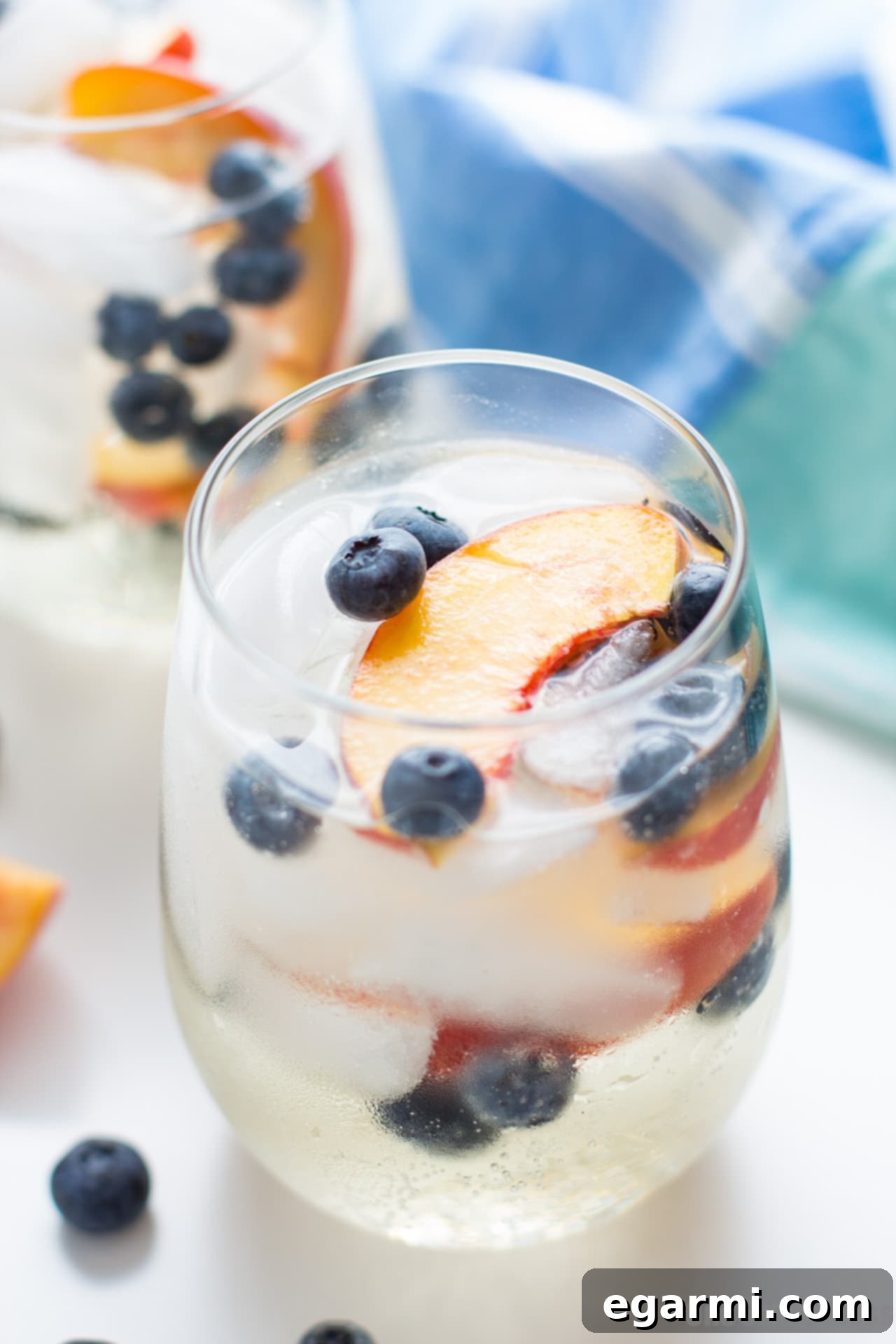Close-up of a glass of Blueberry Peach Sangria with fruit, ready to be served