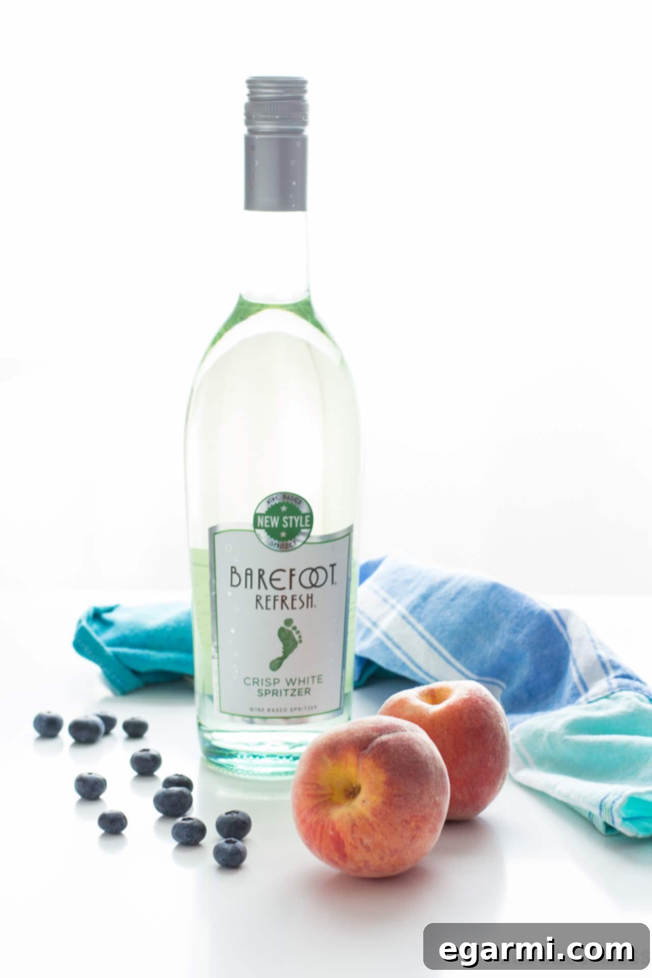 Ingredients for Blueberry Peach Sangria laid out: peaches, blueberries, Barefoot Refresh