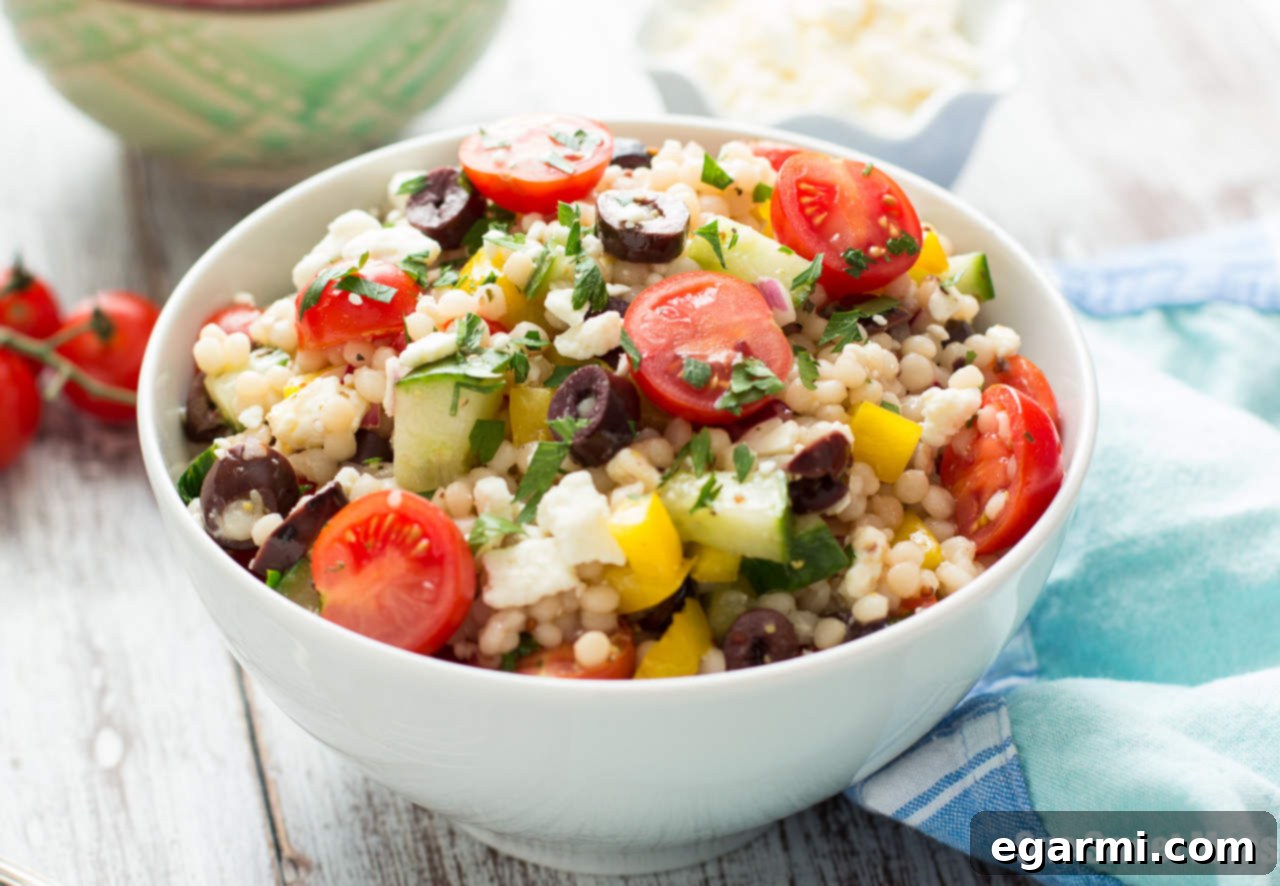 Close-up of Greek Israeli Couscous Salad, showing plump couscous and colorful vegetables