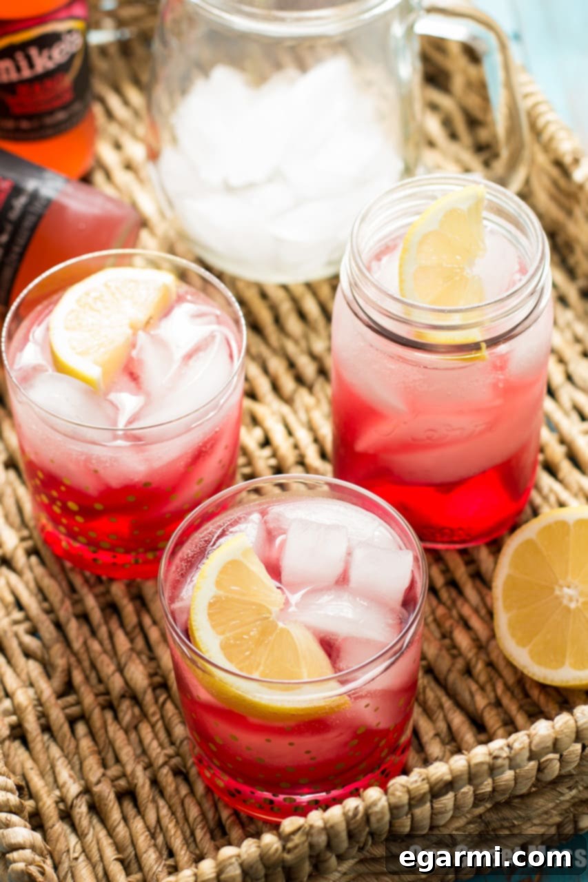 Close-up of a Cran-Apple Splash cocktail in a rocks glass, showcasing the rich red hue and apple garnish, ready for a fall gathering.