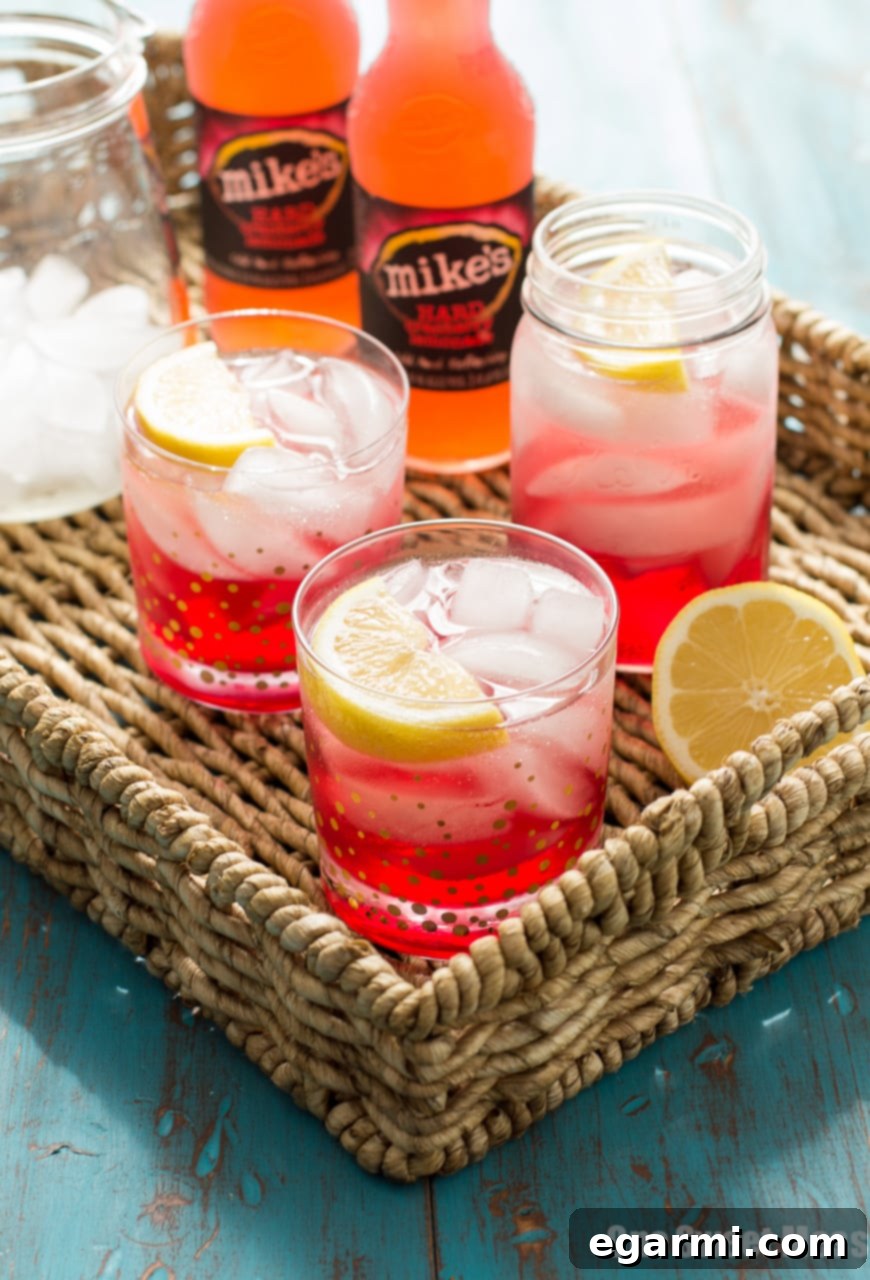 A close-up shot of a Cran-Apple Splash cocktail, garnished with a fresh apple slice, showcasing its inviting deep red color and readiness for enjoyment.