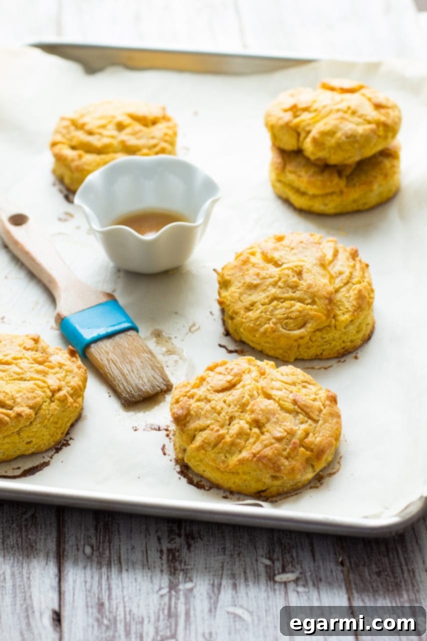 Golden-brown pumpkin biscuits topped with sweet brown sugar pumpkin spice glaze, perfect for fall