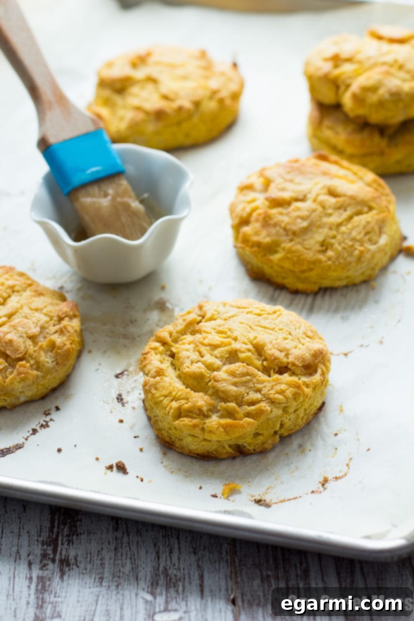 Close-up of a stack of fluffy pumpkin biscuits with a generous drizzle of brown sugar glaze