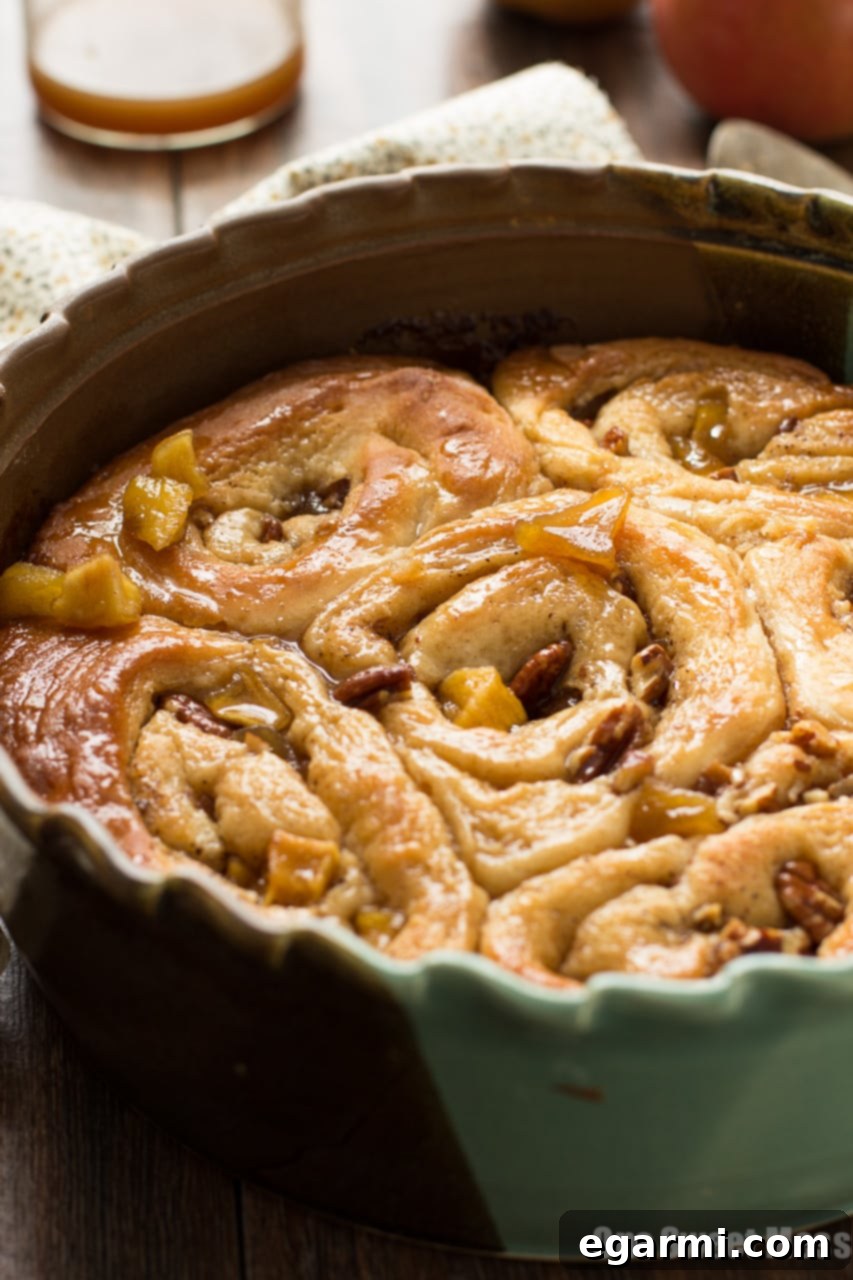 Gooey Caramel Apple Cinnamon Swirls 3 Golden brown Caramel Apple Cinnamon Rolls fresh from the oven, ready to be glazed