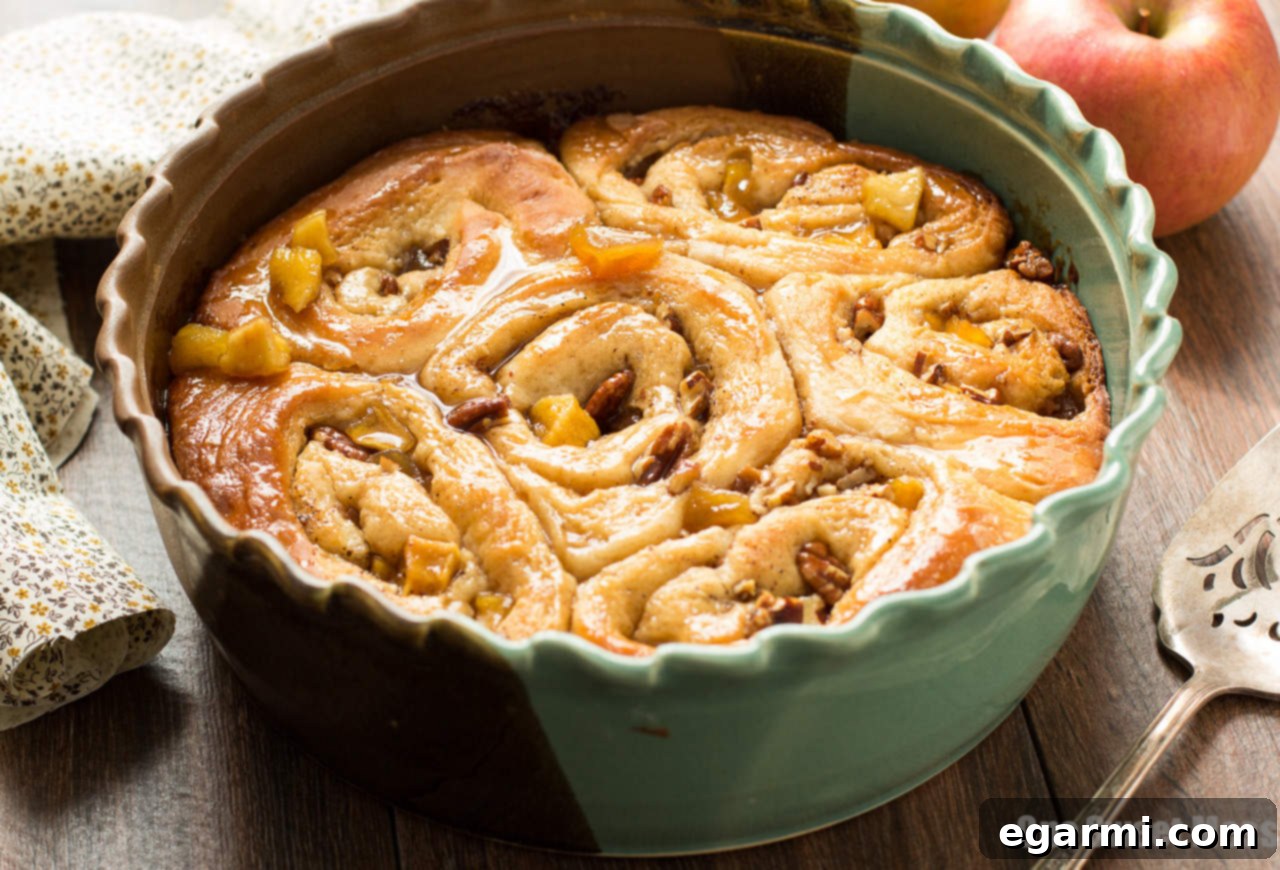 Gooey Caramel Apple Cinnamon Swirls 6 A batch of baked Caramel Apple Cinnamon Rolls, glistening with fresh caramel