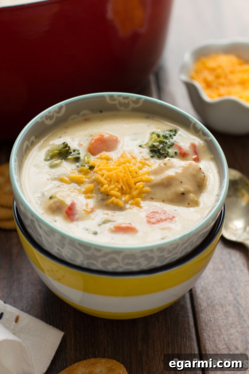 Cheesy Chicken & Veggie Chowder - Spoon lifting creamy soup