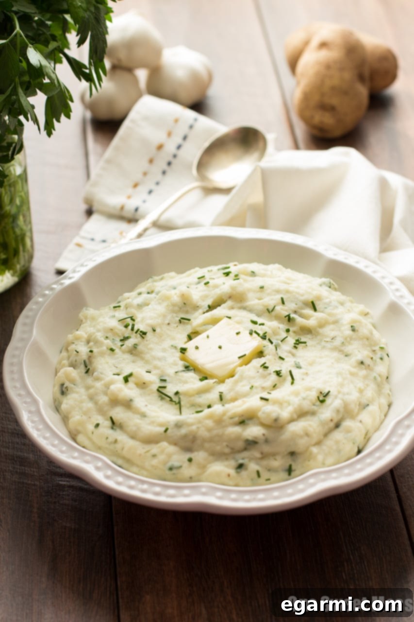 Creamy Roasted Garlic Ranch Mashed Potatoes garnished with fresh chives and parsley